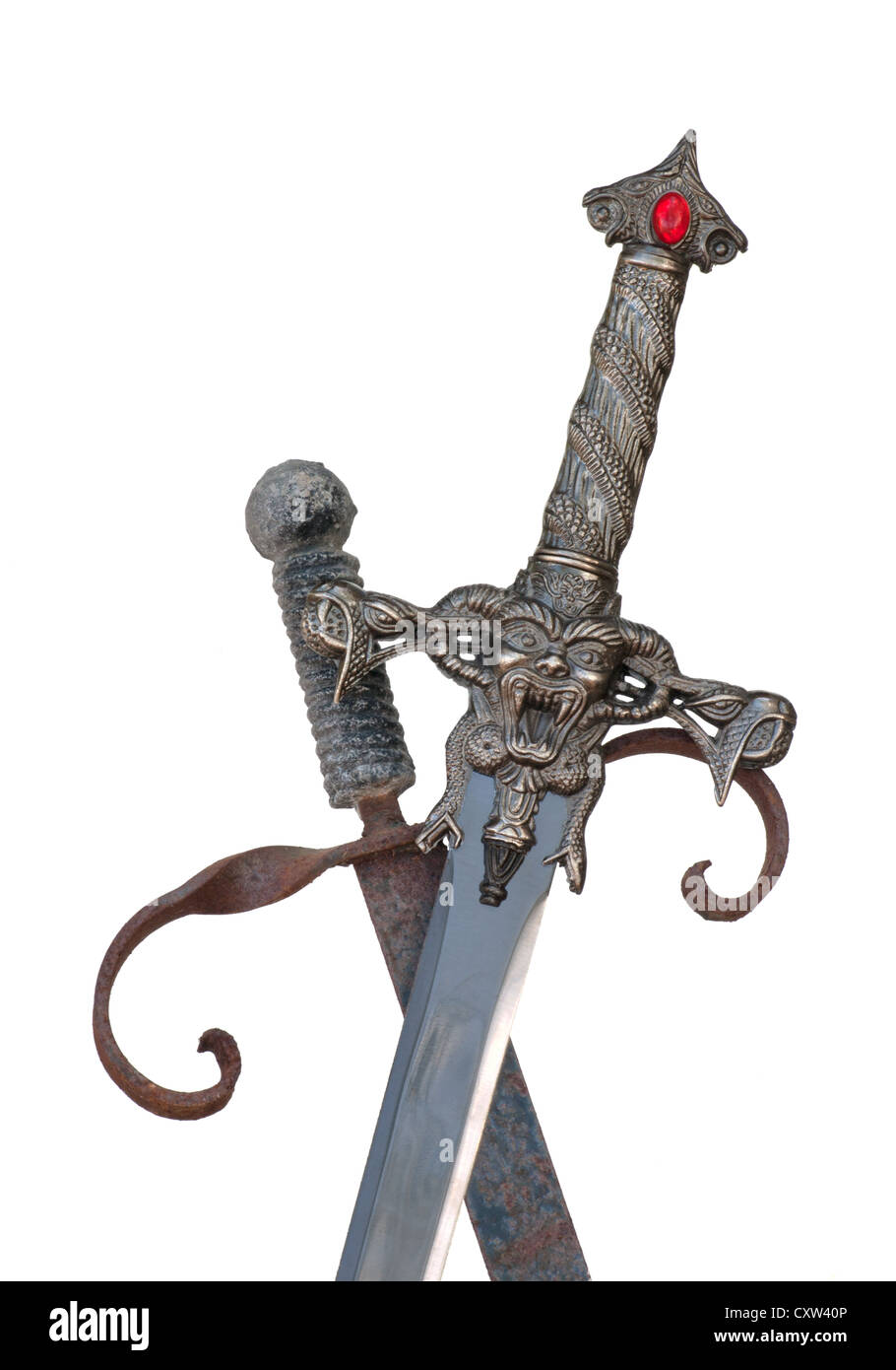 Schwertgriffe. Gekreuzte Schwerter mit Teufel und mit verkrustetem roten Juwel. Stockfoto