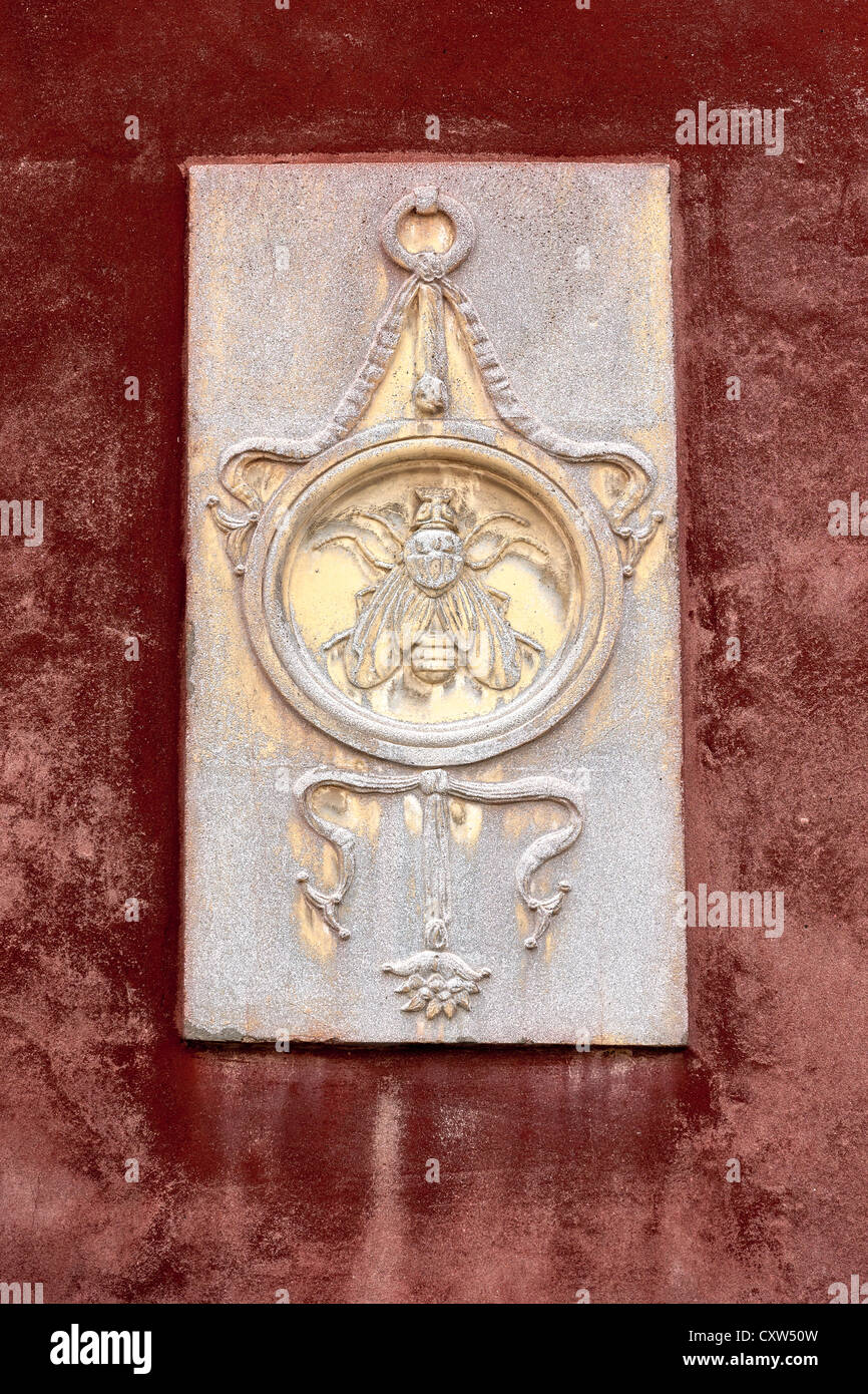 Ein geschnitztes Symbol oder Emblem an der Seite eines Hauses in Venedig Darstellung eine Fliege in einem Kreis Stockfoto