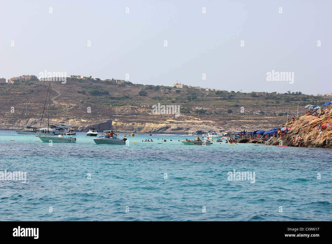 ein Bild von einem Touristenboot Blue Lagoon, Malta, blaues Wasser, Felsen, Tourismus, Touristen, am Meer, Boot, leuchtende Farben, Meer Stockfoto