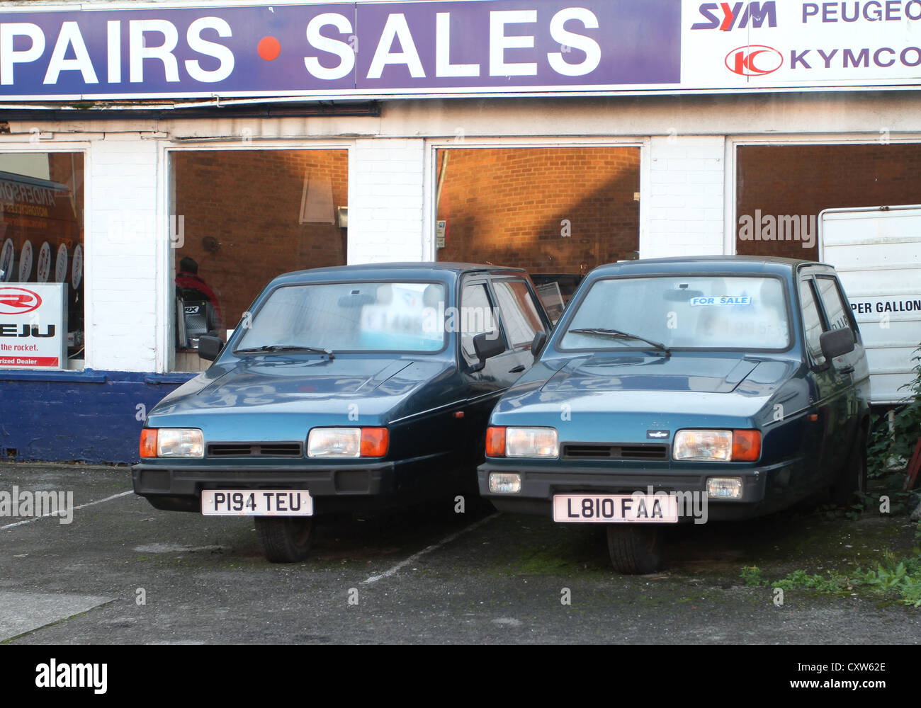 Zwei alte dreirädrige Autos zum Verkauf auf einer Garage-Vorplatz in Bridgwater Somerset eine 16 Jahre alt ist und der andere ist 21! Stockfoto