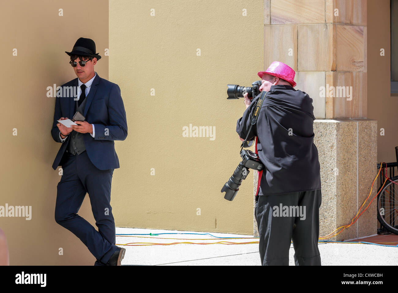 Medien-Fotograf nimmt ein Bild eines jungen Mannes in 1920er-Jahre Retro-Anzug gekleidet Stockfoto