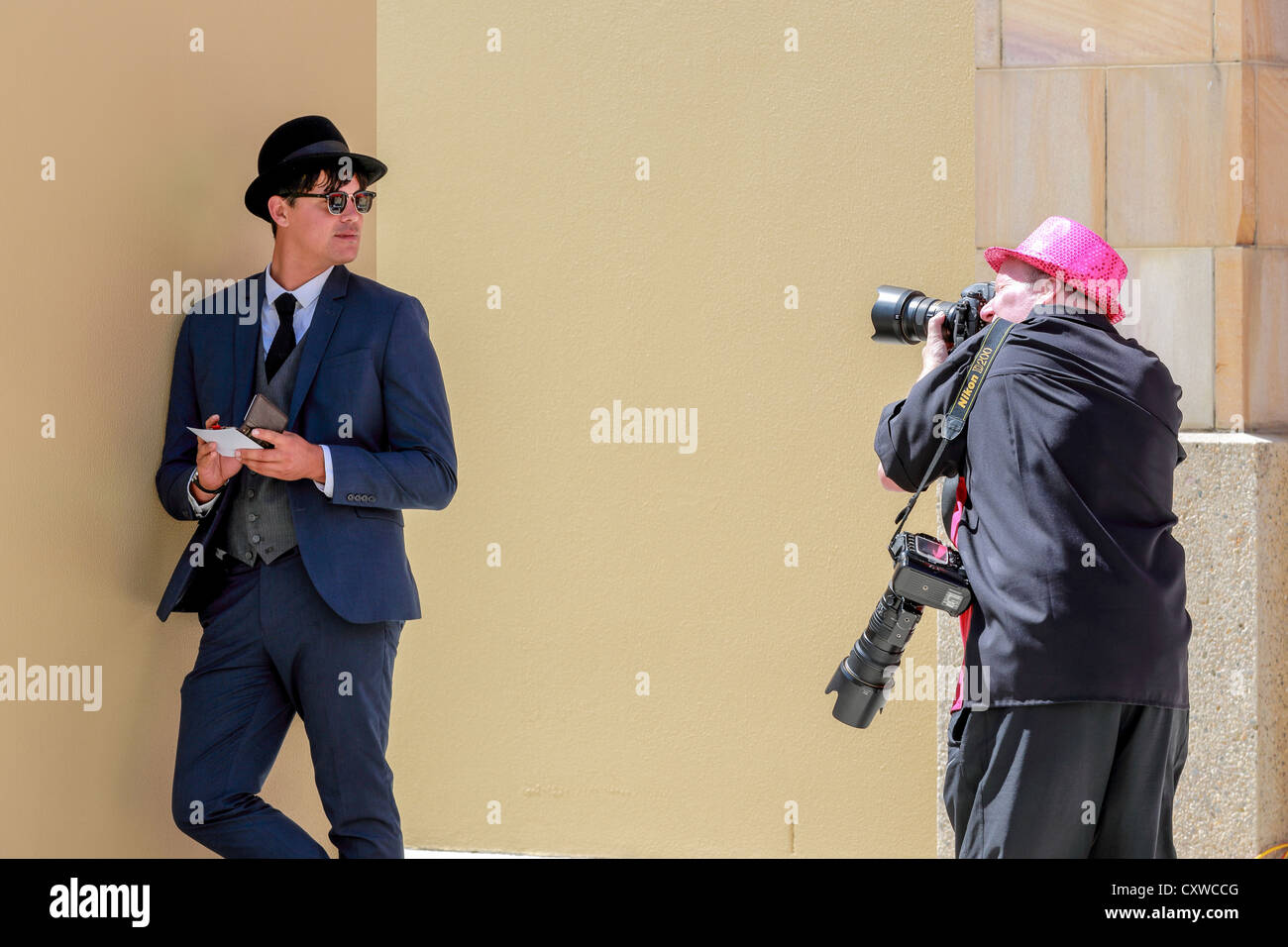 Medien-Fotograf nimmt ein Bild eines jungen Mannes in 1920er-Jahre Retro-Anzug gekleidet Stockfoto