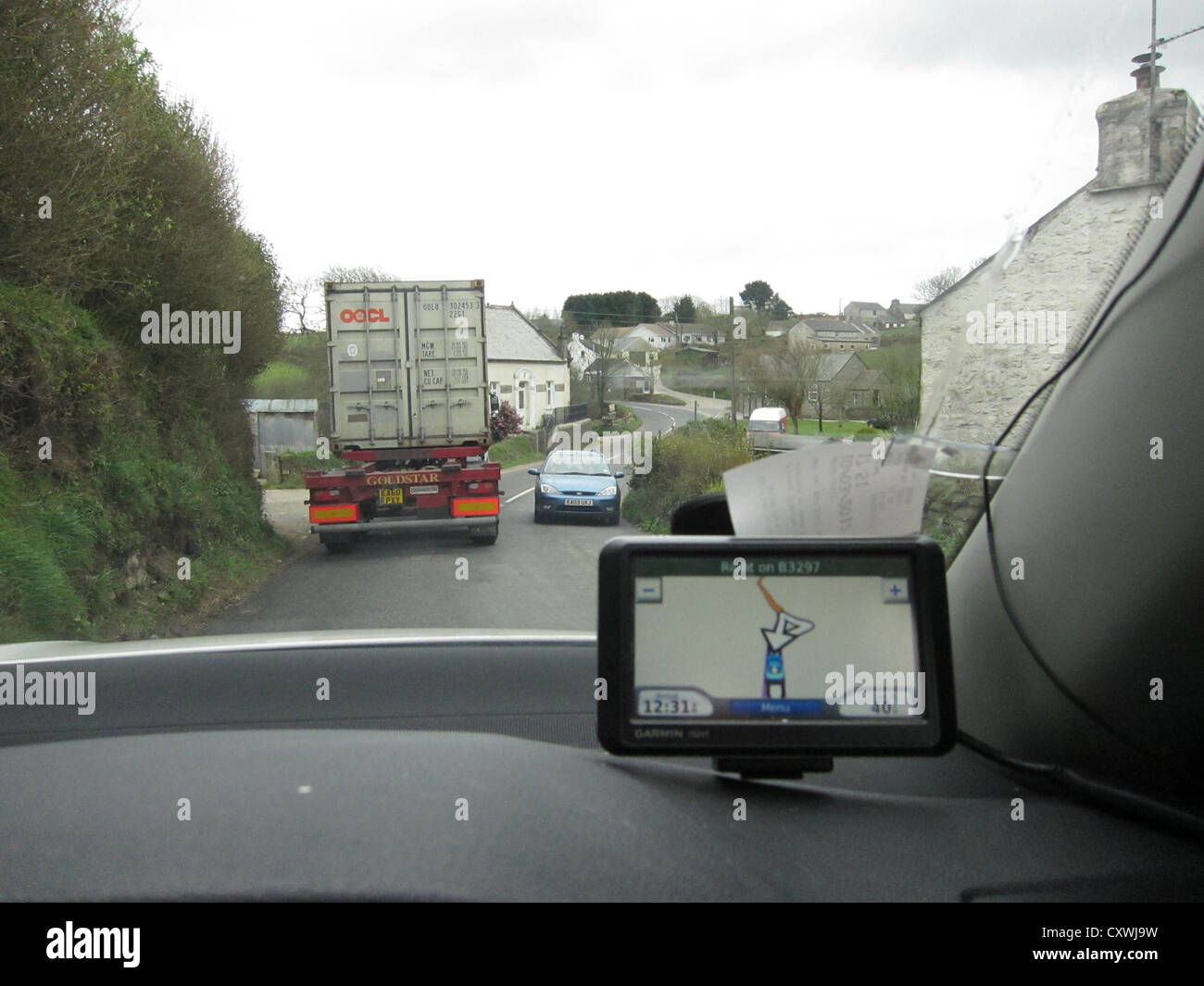 Land-Staus, schwerer LKW trifft ein kleines Auto, Satelliten-Navigations-Bildschirm im Vordergrund Stockfoto