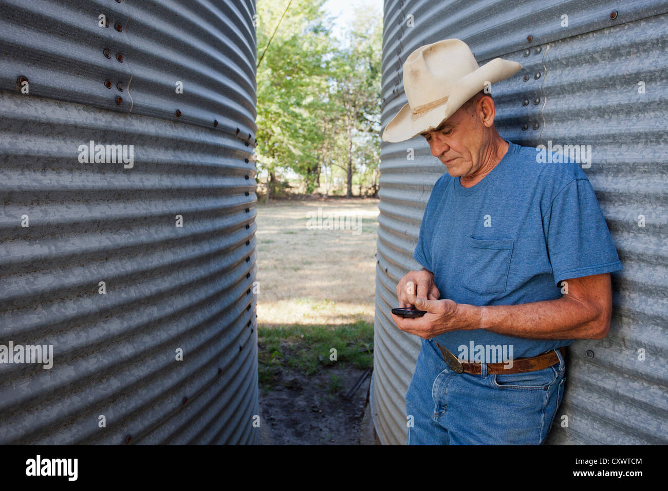 Landwirt mit Handy von silos Stockfoto