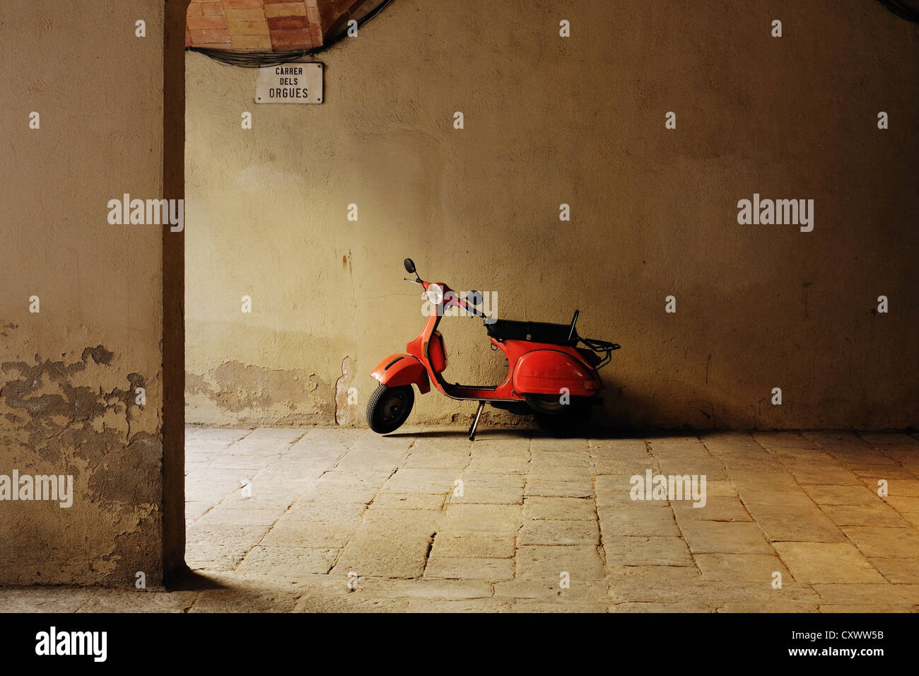 kleine rote Motorrad geparkt auf mittelalterlichen gepflasterten Hof in Barcelona Spanien Stockfoto