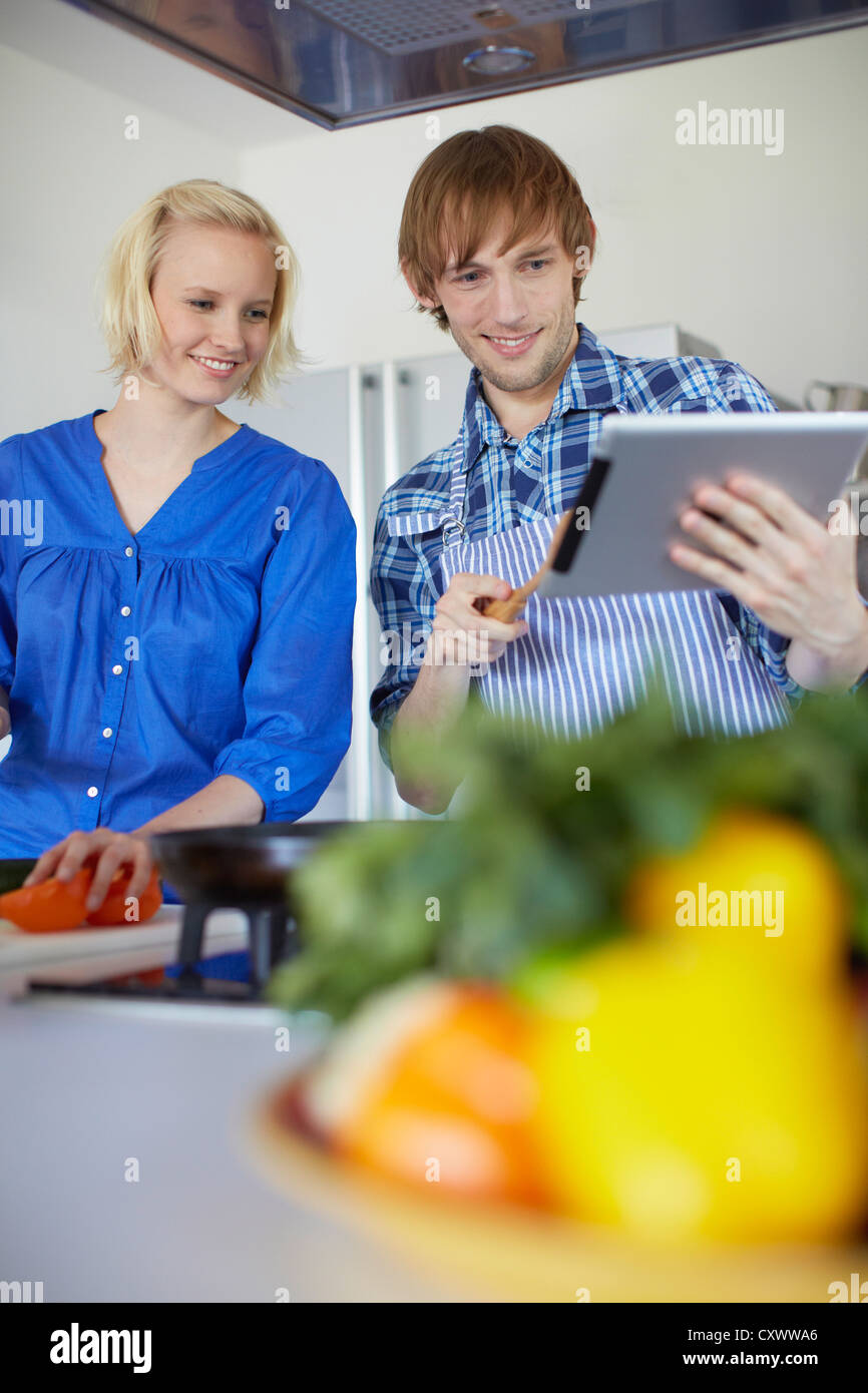 Paar, Kochen mit Tablet-PC Stockfoto