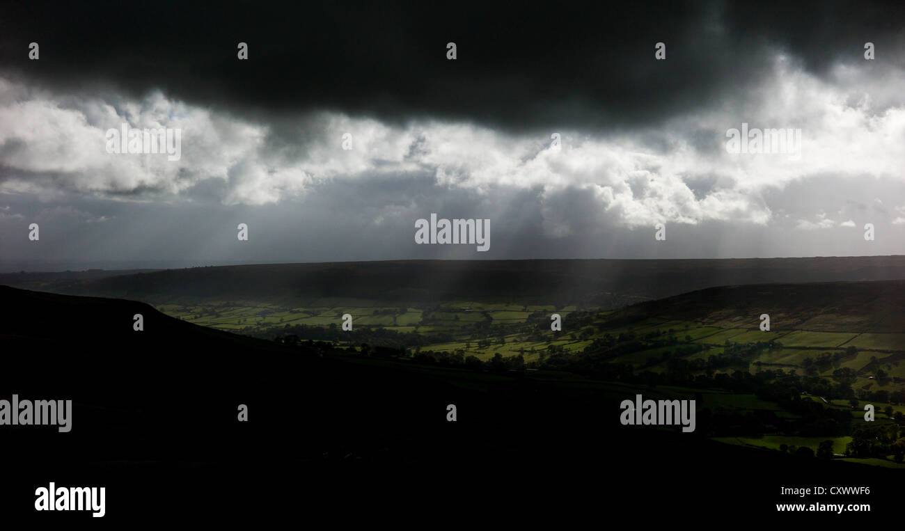 Sonnenlicht bricht durch Gewitterwolken und Feldern mit Blick auf Rosedale auf der North Yorkshire Moors leuchtet Stockfoto