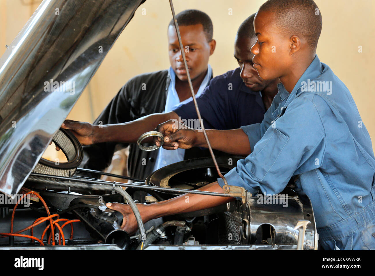 junge Mechaniker arbeitet an einem Automotor. Machui berufliche Zentrum, Machui, Sansibar, Tansania Stockfoto