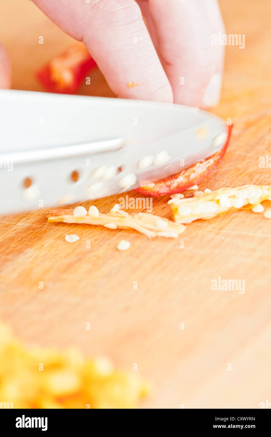 Nahaufnahme von roten Chilischote gehackt wird von einem Koch auf einem Holzbrett Stockfoto