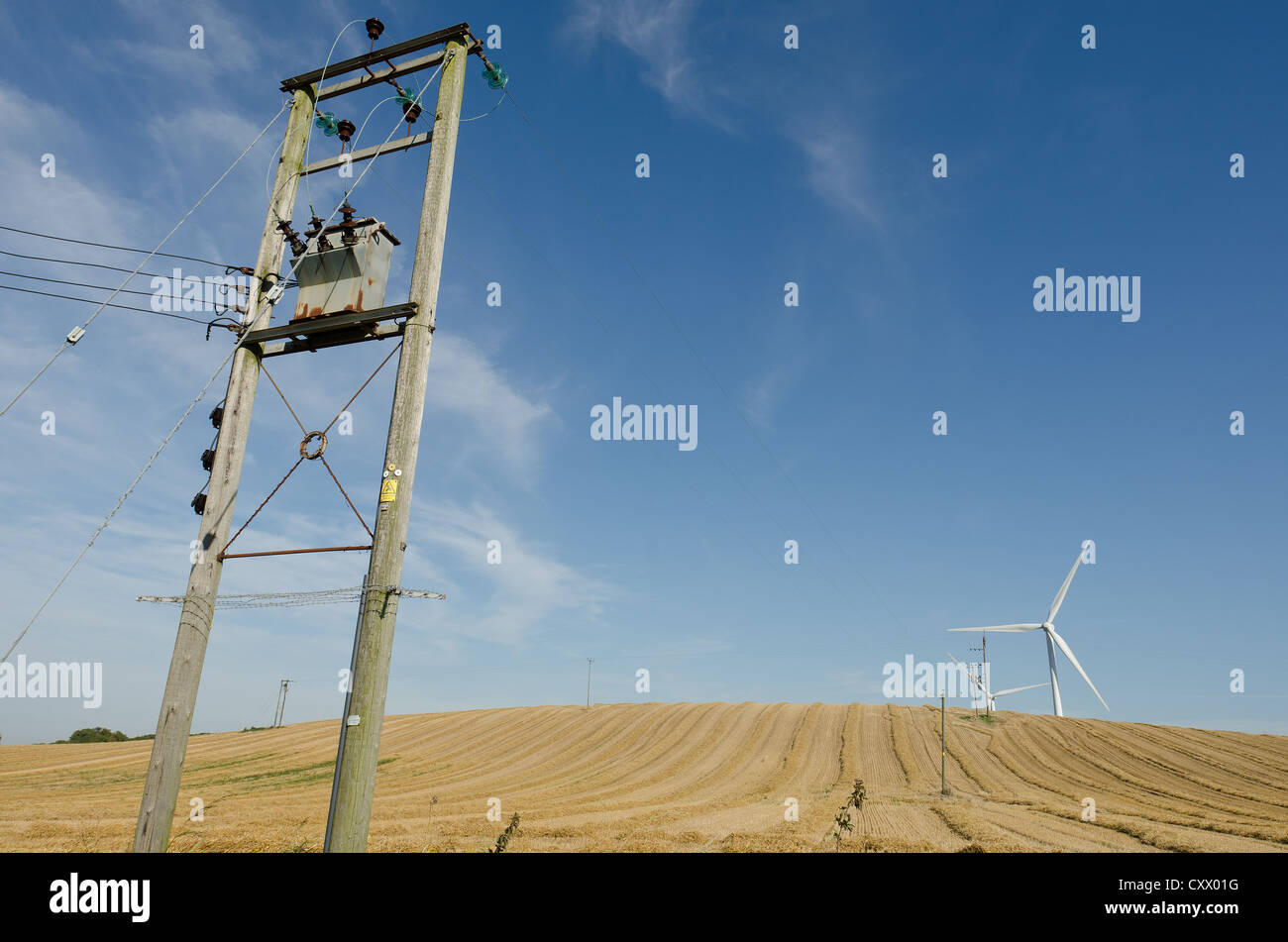 Stromleitungen und Windkraftanlagen Streuung Sunderland Landschaft auf Ackerland geernteten Weizen Feld Vordergrund öffnen Stockfoto