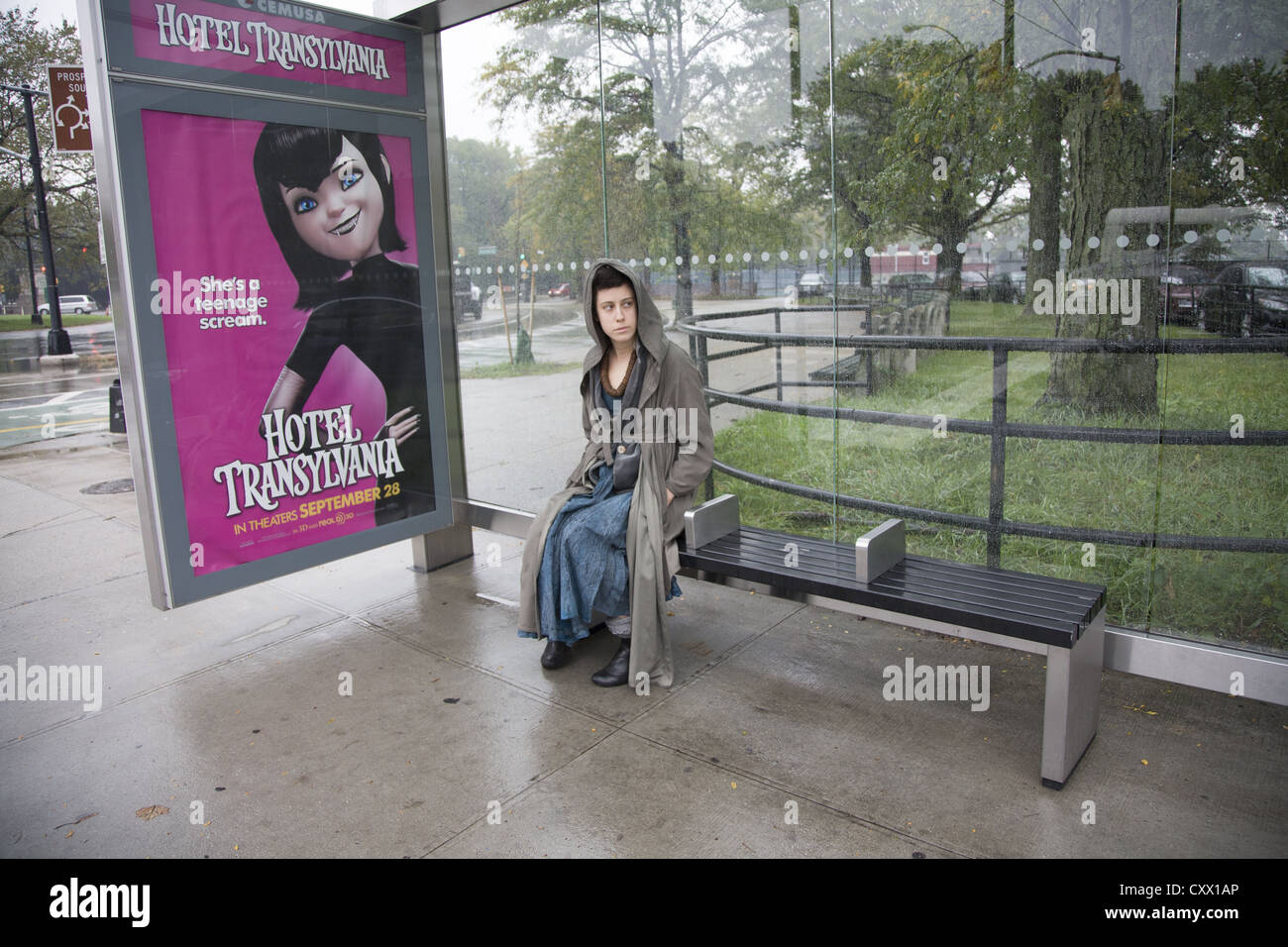 Junge Frau wartet auf einen Bus an einem regnerischen Tag von Prospect Park Parade Gelände in Brooklyn, New York. Stockfoto
