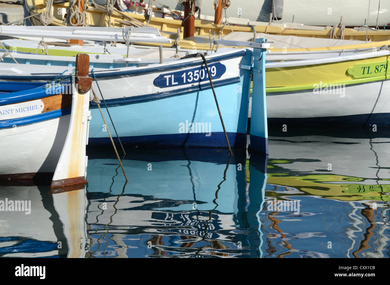 Bunte Holzboote oder Fischerboote bekannt als Pointus, & Reflexionen im Hafen oder Hafen von Sanary-sur-Mer Var Provence Frankreich Stockfoto