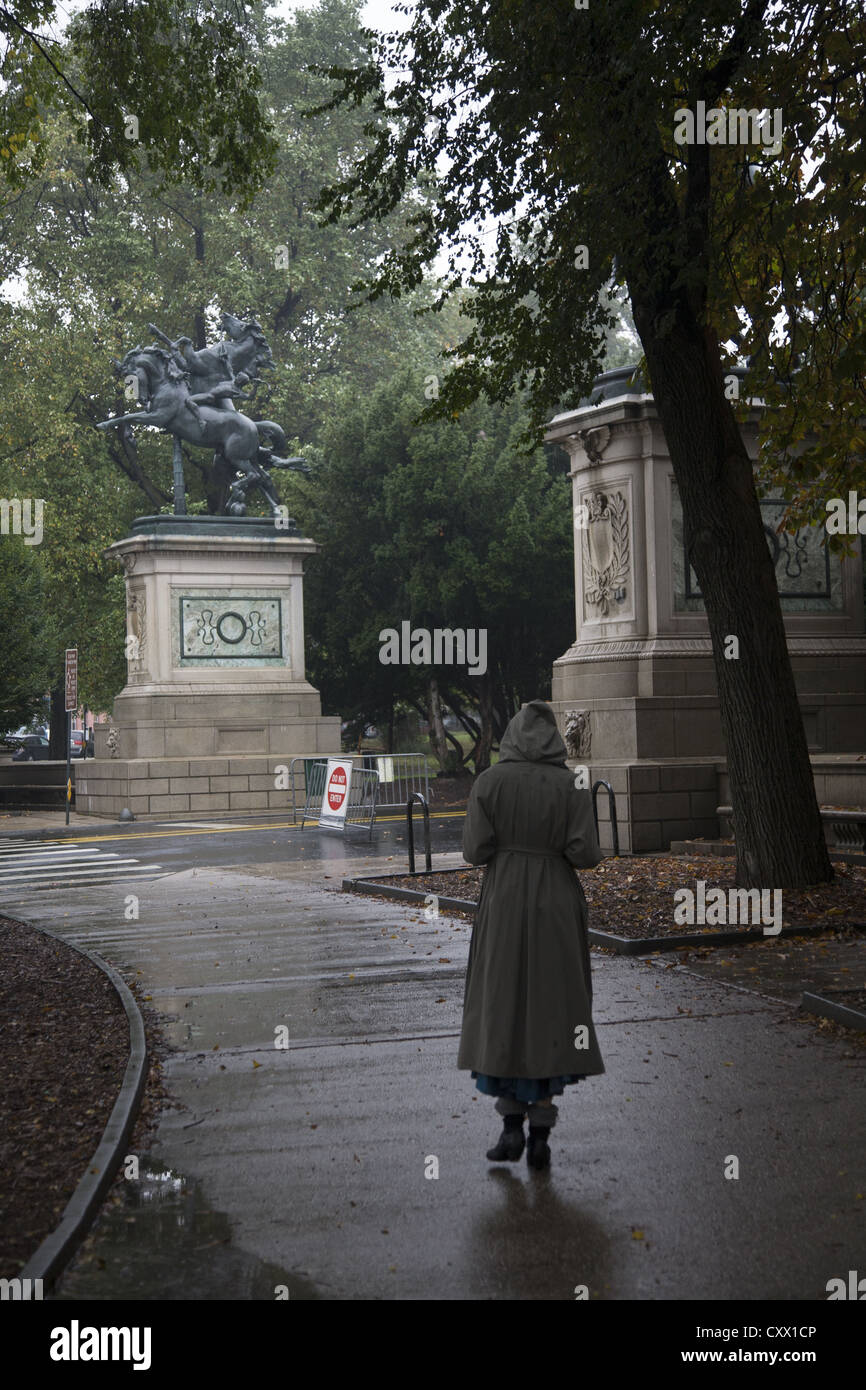 Frau geht allein an einem regnerischen Tag am Südeingang des Prospect Park in Brooklyn, New York. Stockfoto