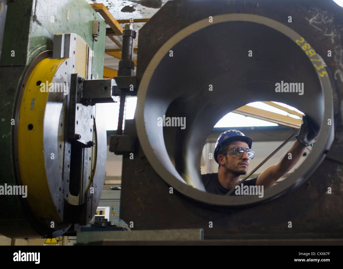 Kaukasische Arbeiter arbeiten auf Stahlrohr in Fabrik Stockfoto