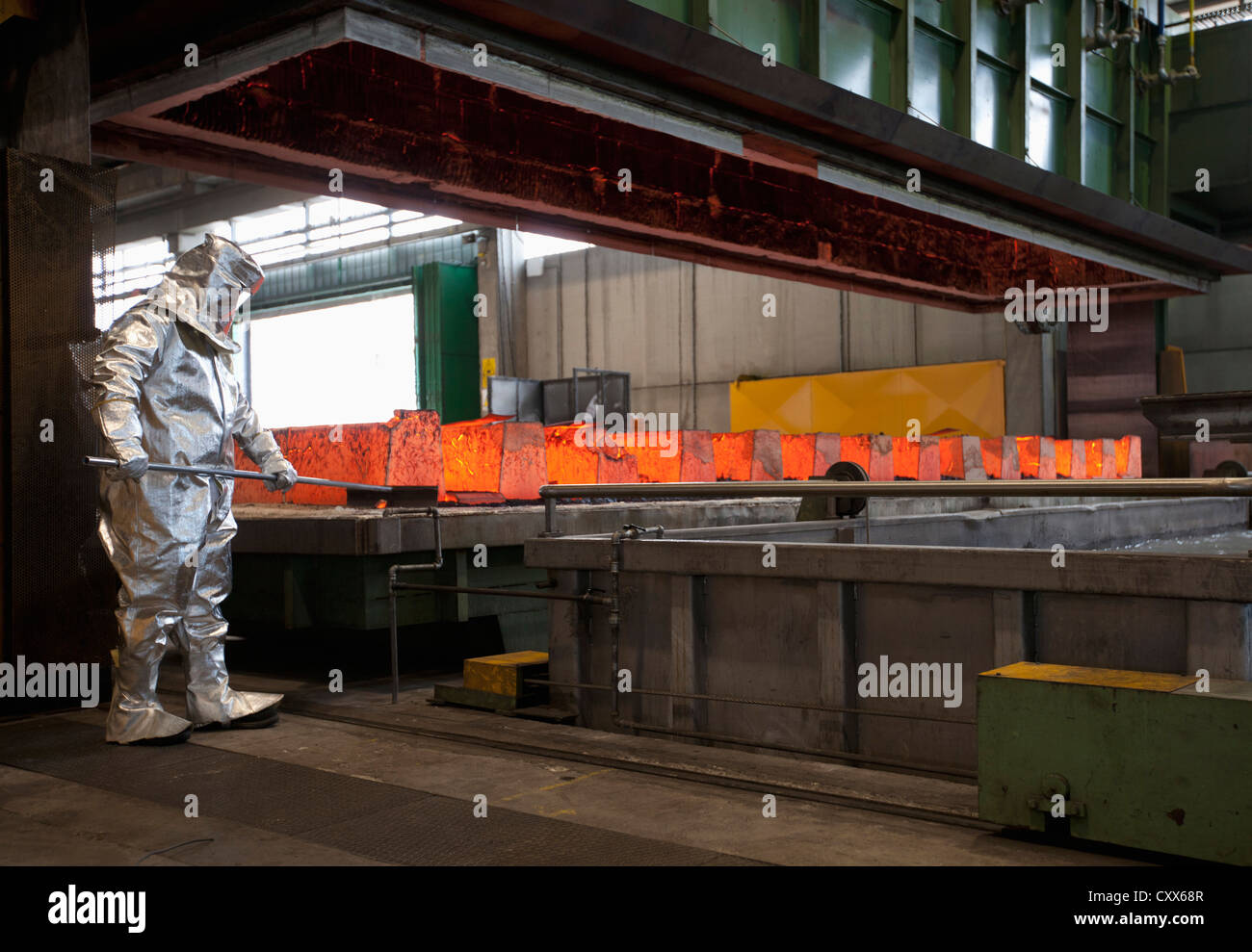 Arbeiter arbeiten mit heißem Metall in Stahlwerk Stockfoto