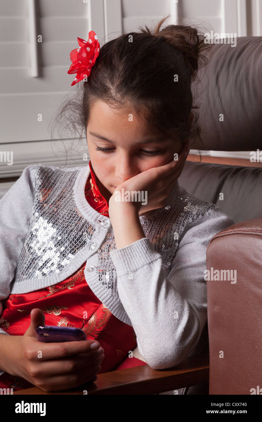 Mädchen, 10 Jahre alt, lesen Nachricht auf einem Smartphone Stockfoto