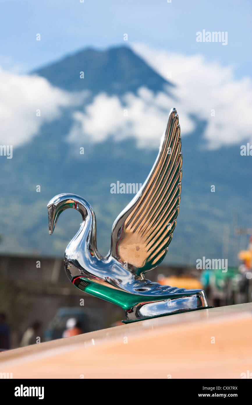 Kühlerfigur auf Bus bei Antigua Busbahnhof mit aktiven Fuego Vulkan übersehen. Guatemala, Mittelamerika Stockfoto