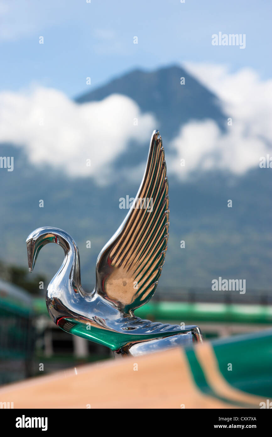 Kühlerfigur auf Bus bei Antigua Busbahnhof mit aktiven Fuego Vulkan übersehen. Guatemala, Mittelamerika Stockfoto