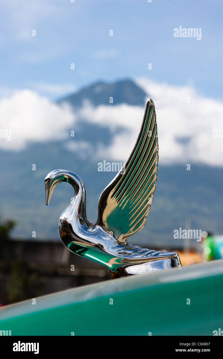 Kühlerfigur auf Bus bei Antigua Busbahnhof mit aktiven Fuego Vulkan übersehen. Guatemala, Mittelamerika Stockfoto