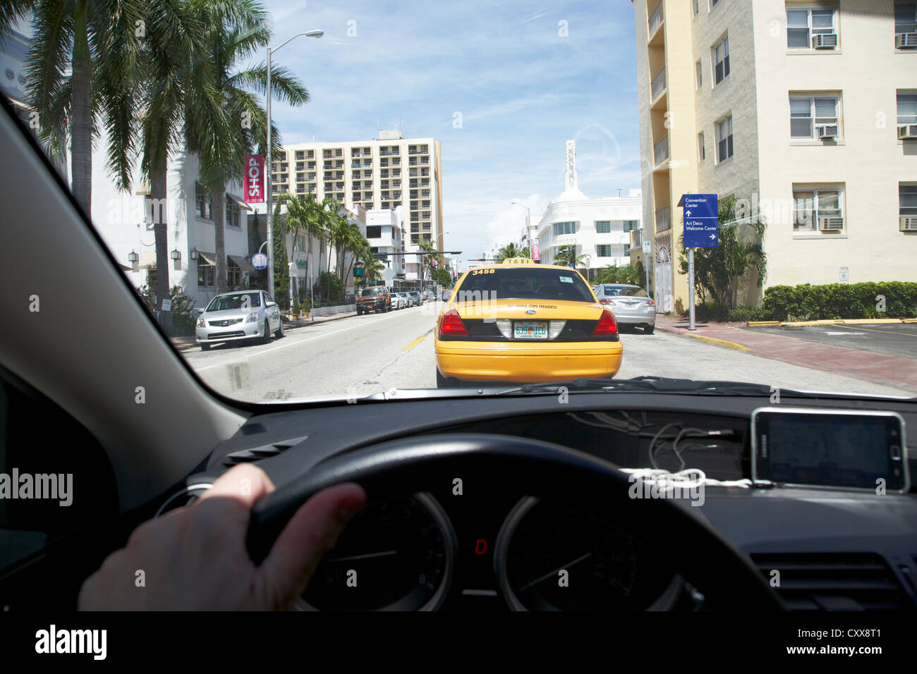 Mans Hand am Rad fahren entlang der Collins Avenue in Miami South Beach nach einer gelben Taxi Florida Usa Stockfoto