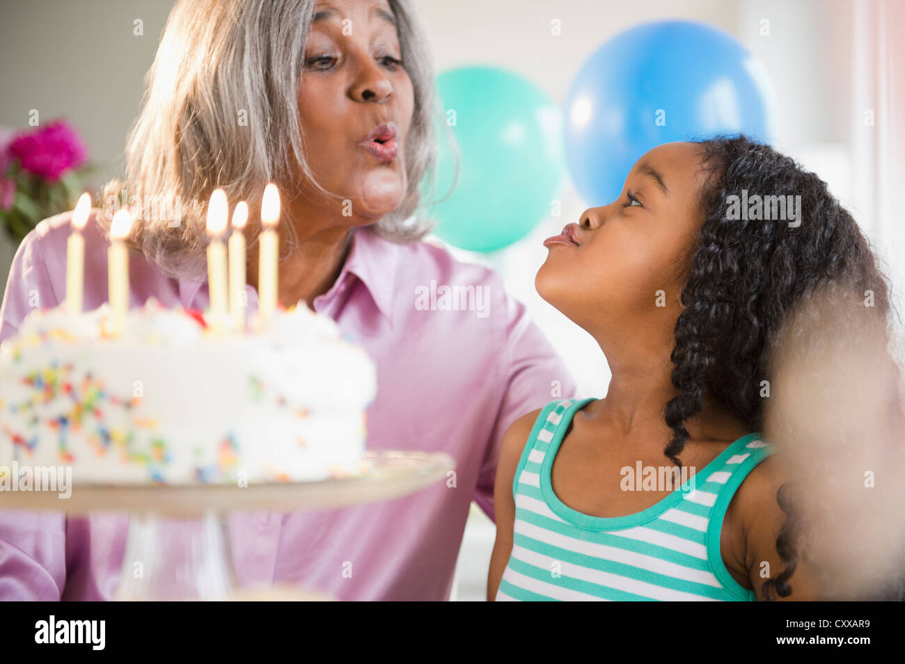 African American Großmutter und Enkelin mit Geburtstagstorte Stockfoto