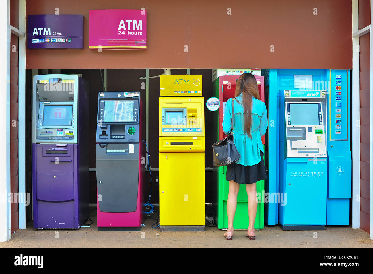 Frau ausziehen Geld aus der Outdoor-Bank terminal Stockfoto