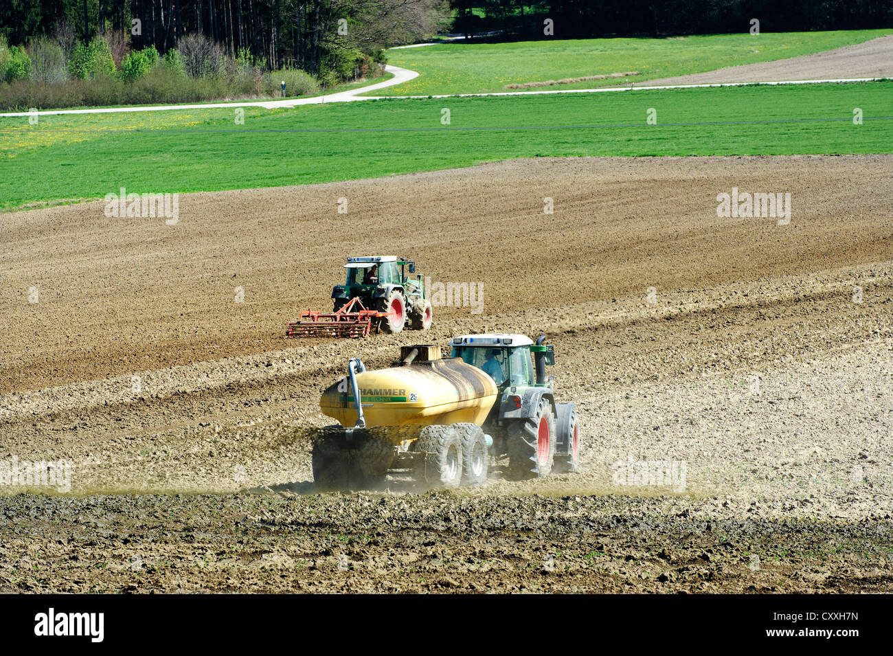 Traktoren pflügen ein Feld, Bayern, Oberbayern Stockfoto