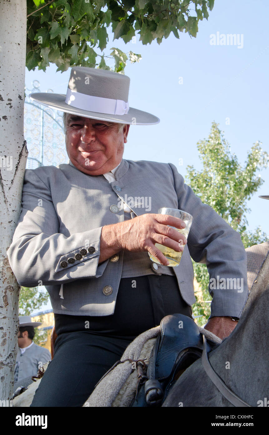 Mann auf Pferd Hut Cordobes während spanische Jahrmarkt trinken ein Sherry, Fuengirola, Andalusien, Spanien. Stockfoto