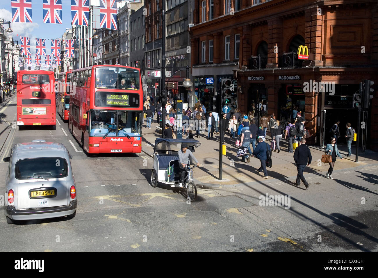 Verkehr auf der Oxford Street, Doppeldecker-Busse, Fahrrad Taxi, Union Jack, Nationalflagge, London, England, Vereinigtes Königreich, Europa Stockfoto