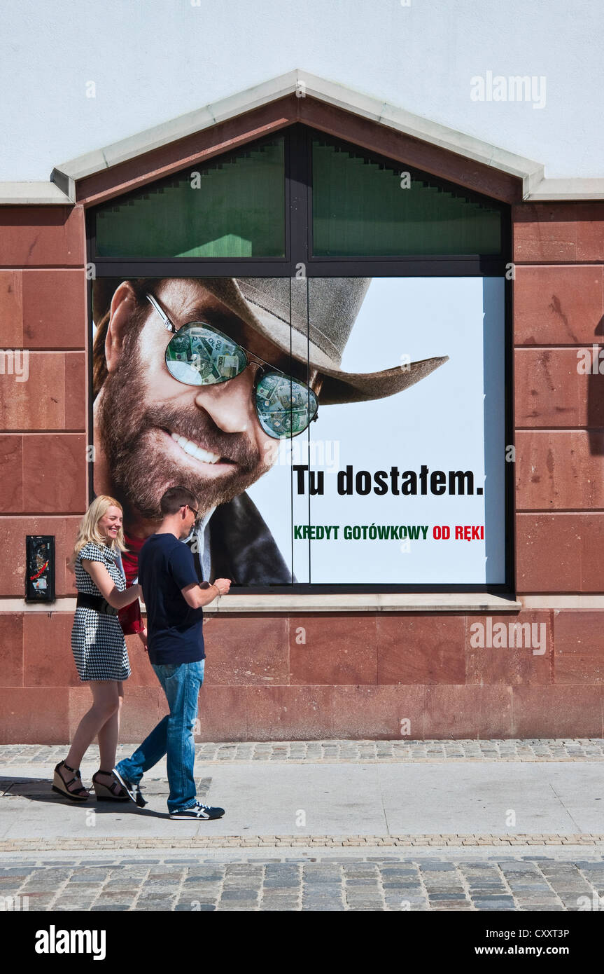 Kinderwagen zu Fuß durch "habe ich es hier, Barkredit sofort," Plakat mit dem Schauspieler Chuck Norris Werbung für Bank Zachodni WBK in Wroclaw, Polen Stockfoto