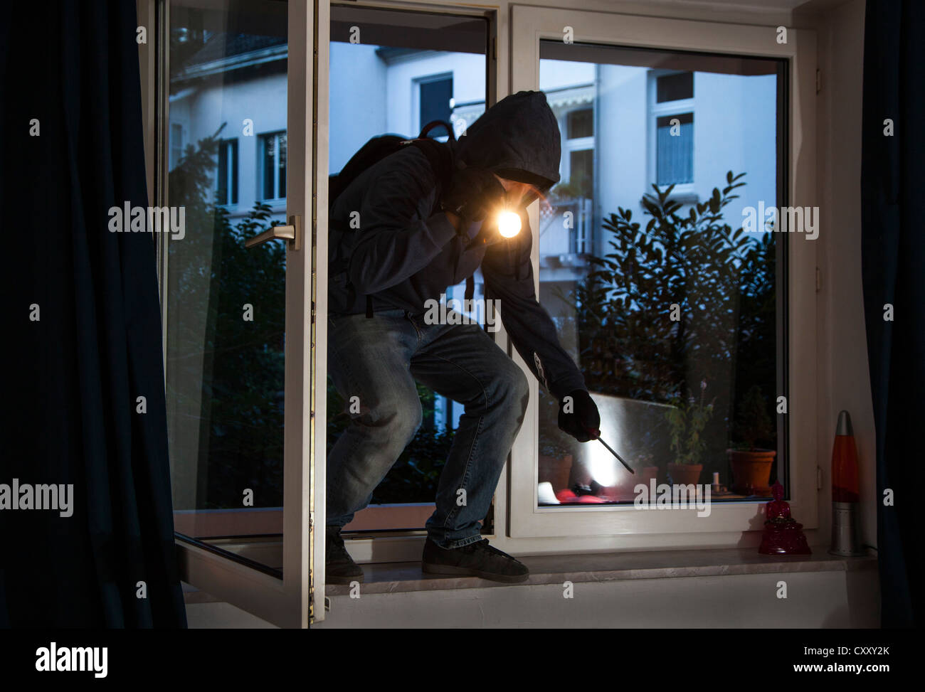 Einbrecher bricht in eine Wohnung. Symbol-Bild. Stockfoto
