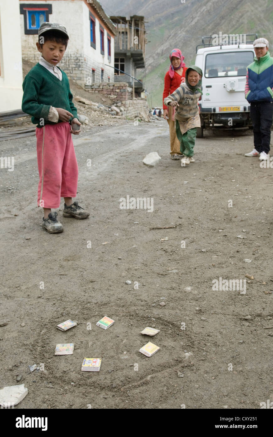 Kinder spielen Steinwürfe auf Streichholzschachteln in Schlamm Dorf, Spiti, Nordindien Stockfoto
