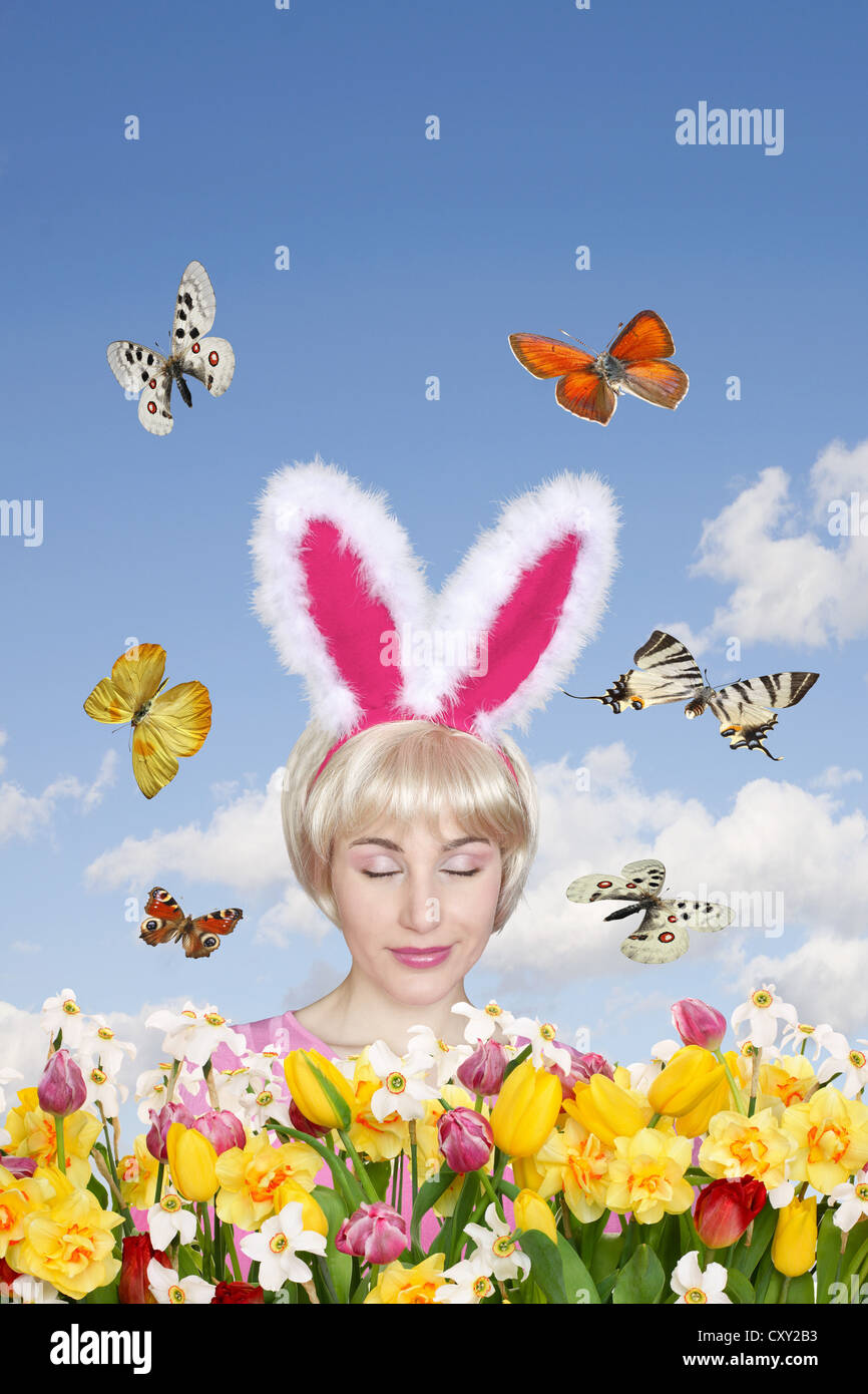 Frau mit Hasenohren, Blumenfeld, Schmetterlinge Stockfoto