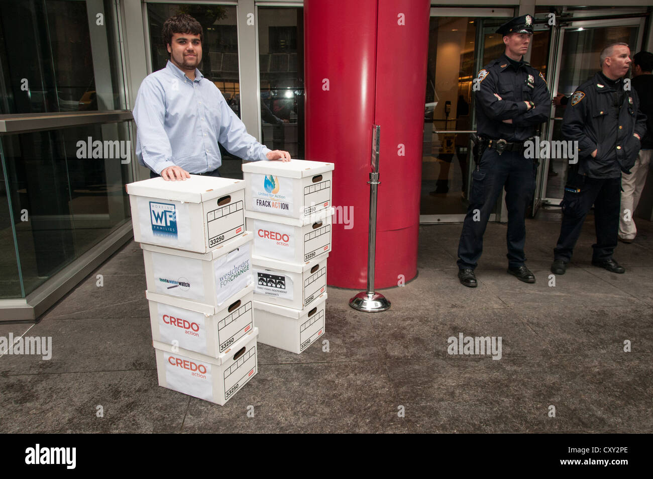 Andrew Lease, Assistentin in NY Gouverneur Andrew Cuomo Büro, mit Boxen von Anti-Fracking Petitionen, Manhattan, New York, USA Stockfoto
