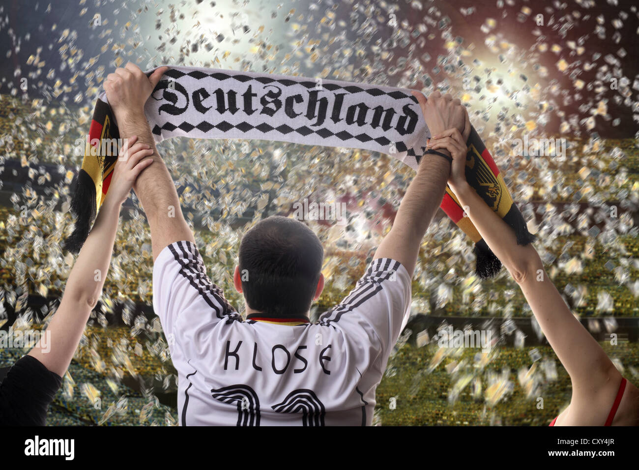 Fußball-Fan hält einen deutschen Fans Schal, gesehen von hinten mit Konfetti in einem Fußballstadion Stockfoto