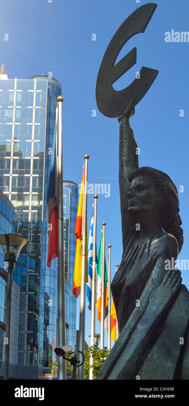 Europa hält ein Euro-Symbol vor dem Büro des Europäischen Parlaments, Brüssel, Belgien (Europäische Flaggen im Hintergrund) Stockfoto