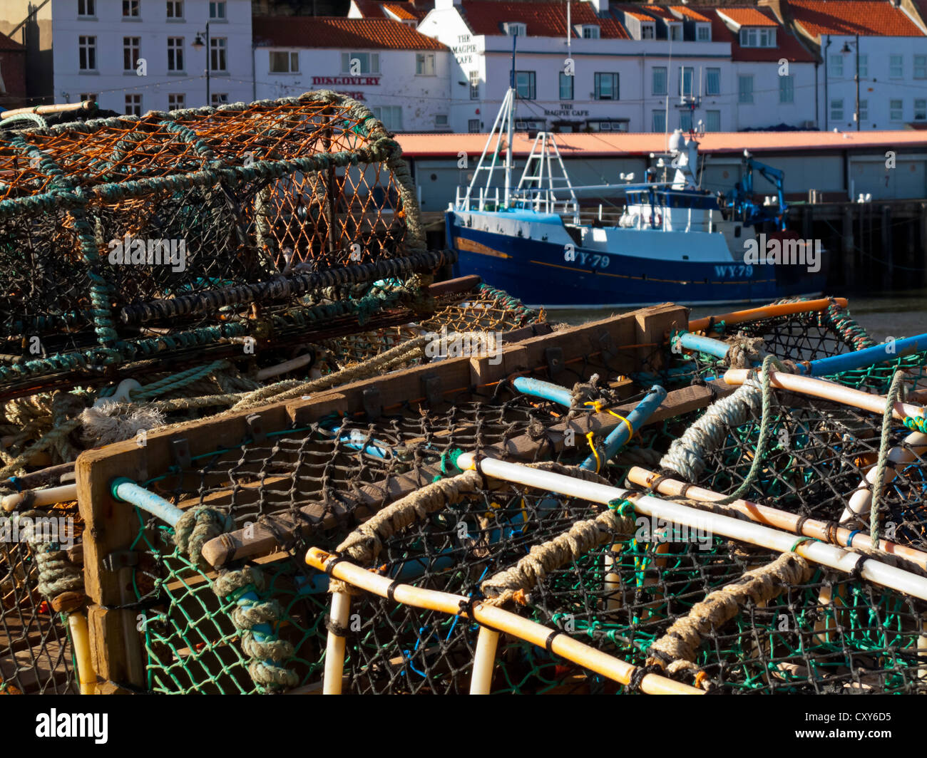 Hummer und Krabben Netze mit Fischerboot auf Distanz Whitby Hafen North Yorkshire England UK an der Nordseeküste Stockfoto