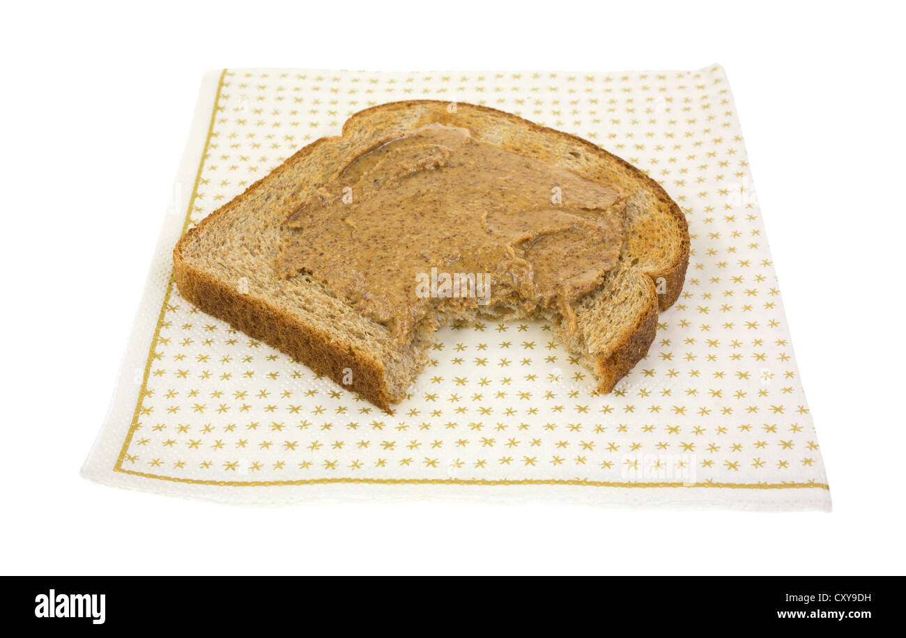 Ein Stück Weizen Toast mit Mandelbutter, die einmal auf einer Papierserviette gebissen worden ist. Stockfoto