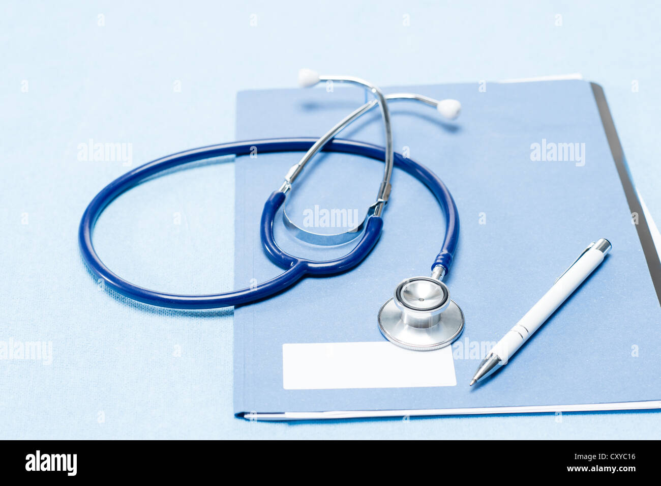 Stethoskop und Stift über medizinische Patientenakte auf blauem Hintergrund Stockfoto