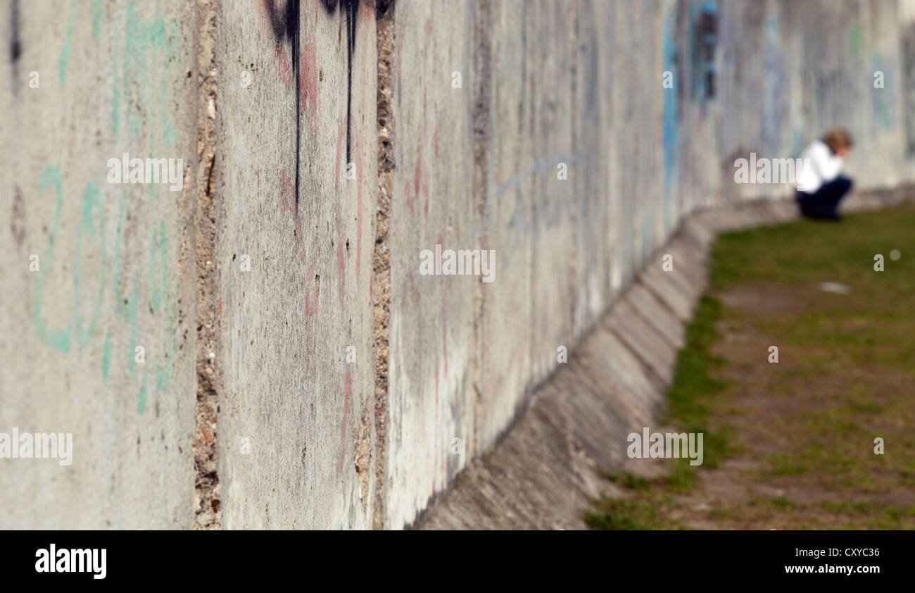 Verzweifelte Frau sitzt an der ehemaligen Berliner Mauer, Berlin-Mitte, Berlin Stockfoto