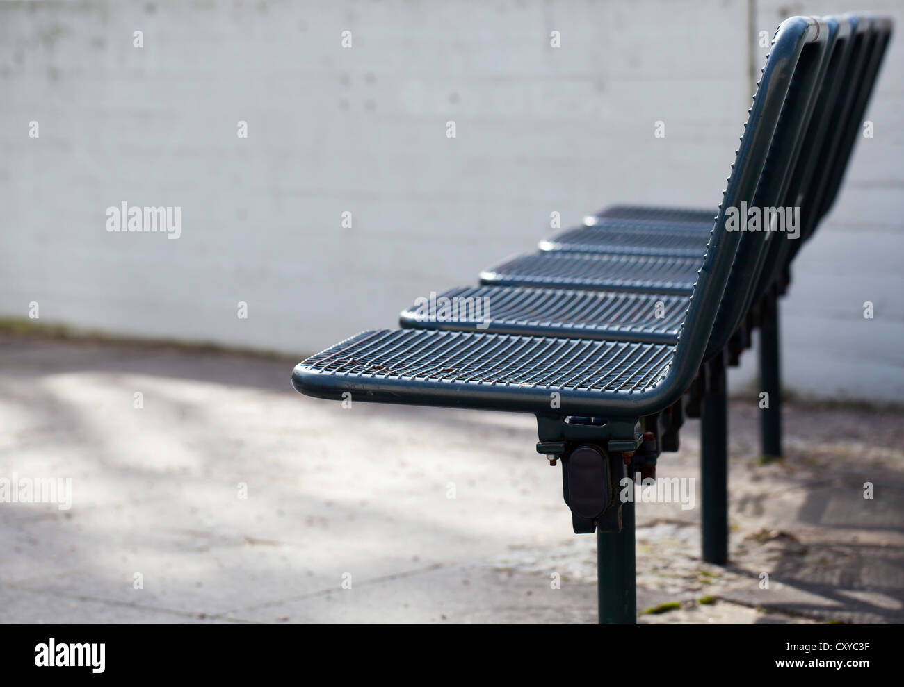 Alte Stühle Metall vor einer grauen Betonwand auf einem Spielplatz, Hochhaus Immobilien in Berlin Stockfoto