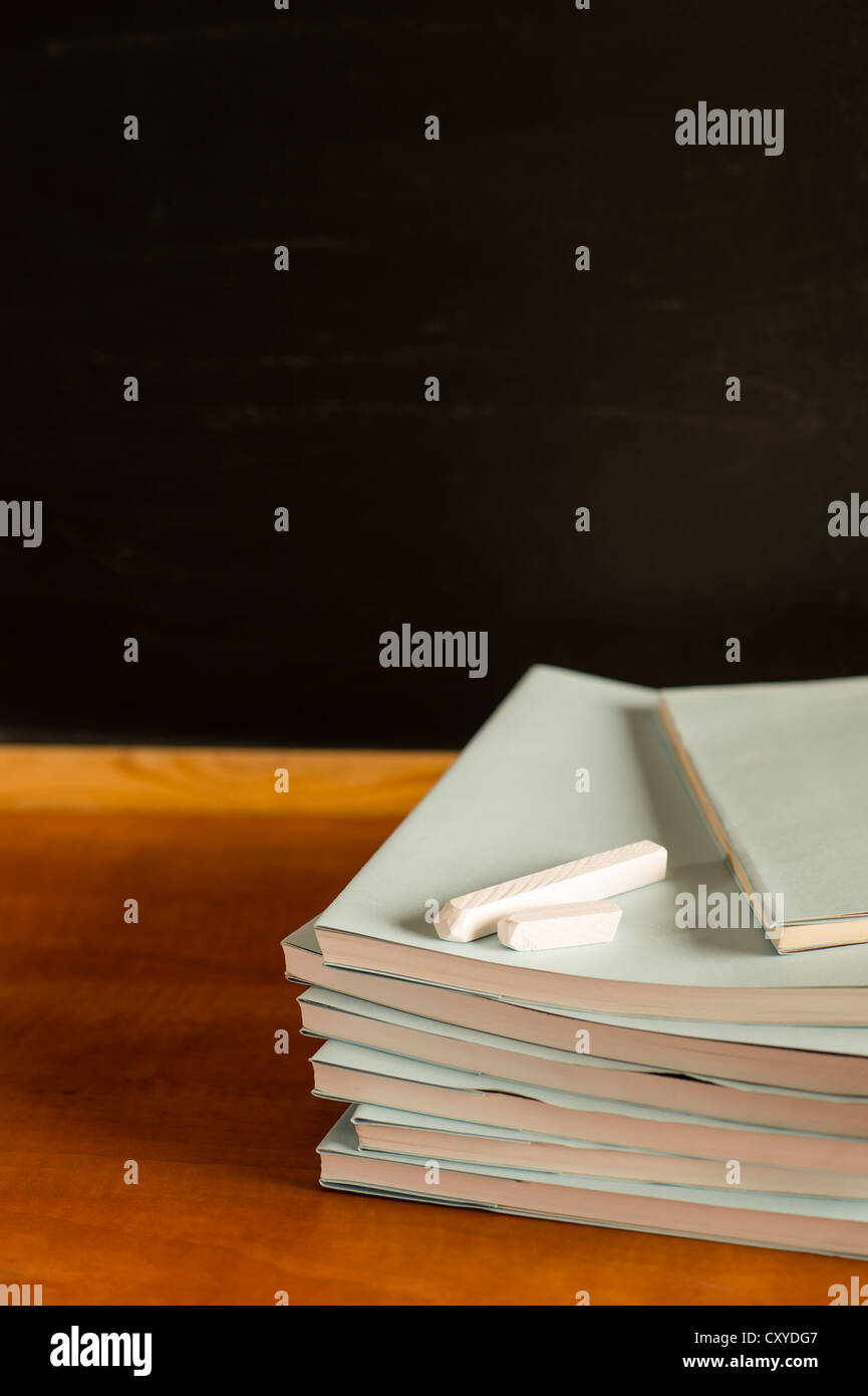 Akademische Notizblöcke und Kreiden auf traditionelles Dekor Schreibtisch aus Holz Stockfoto