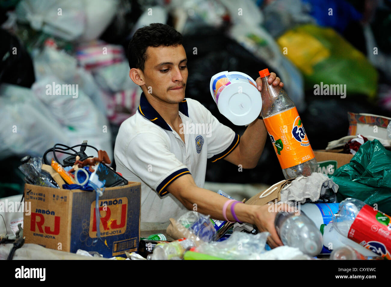 Junger Mann sortieren von Wertstoffen, die mittelständische Unternehmen von einer Frauenorganisation Müll zu trennen und die Ressourcen zu verkaufen Stockfoto