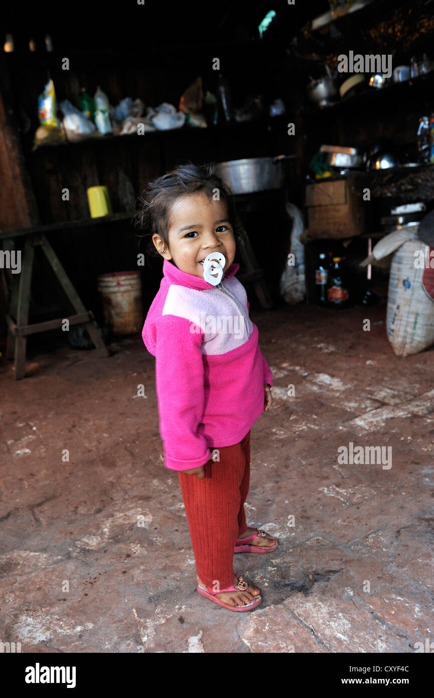Kleines Mädchen mit einem Schnuller, Lächeln, stehen in der einfachen Küche der Landarbeiter, Comunidad Arroyito, Departamento Concepcion Stockfoto