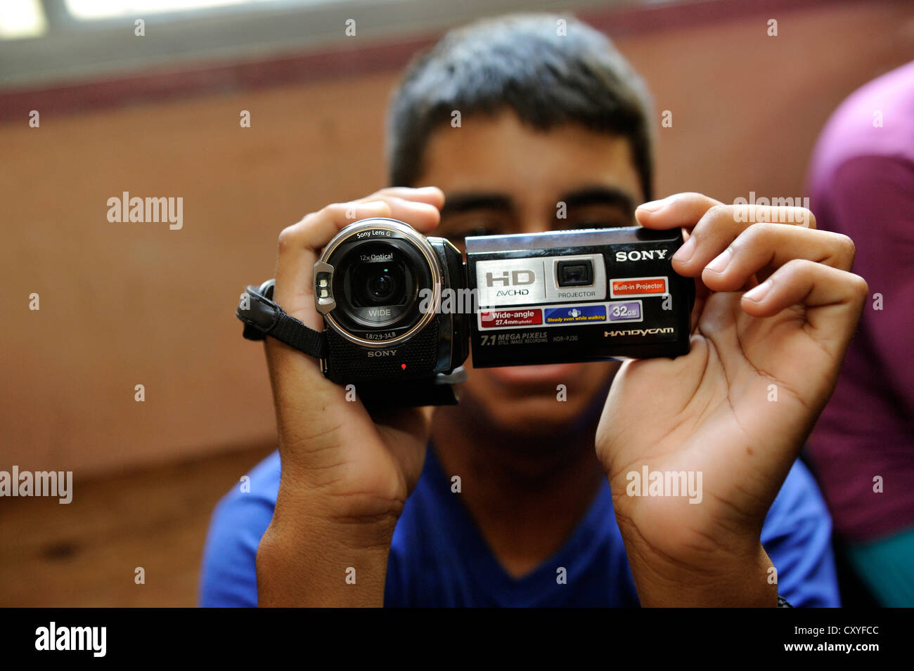 Video-Kurs für Jugendliche Teilnehmer ist eine Video-Kamera in den Händen hält zum allerersten Mal, Organisation "El Stockfoto
