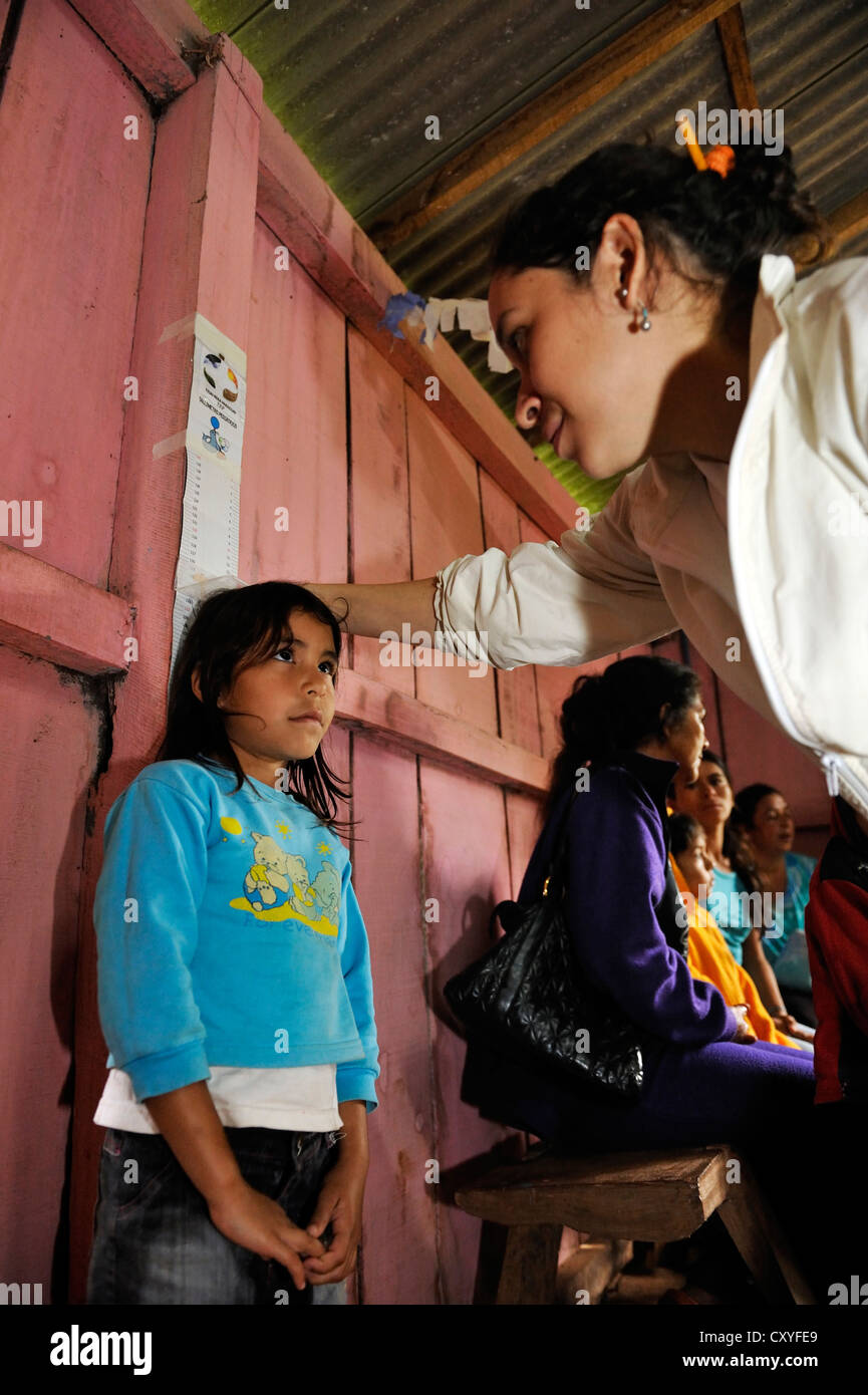 Die Höhe eines Mädchens wird, eine Hilfsorganisation, die Kinder in einer ländlichen Gemeinde, Comunidad Martillo Prüfung gemessen Stockfoto