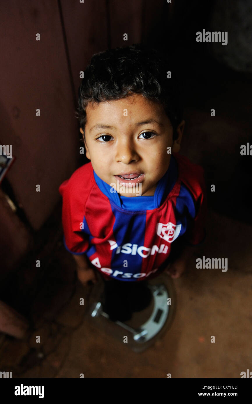 Junge auf eine Personenwaage, eine Hilfsorganisation, die Kinder in einer ländlichen Gemeinde, Comunidad Martillo Caaguazu Prüfung stand Stockfoto