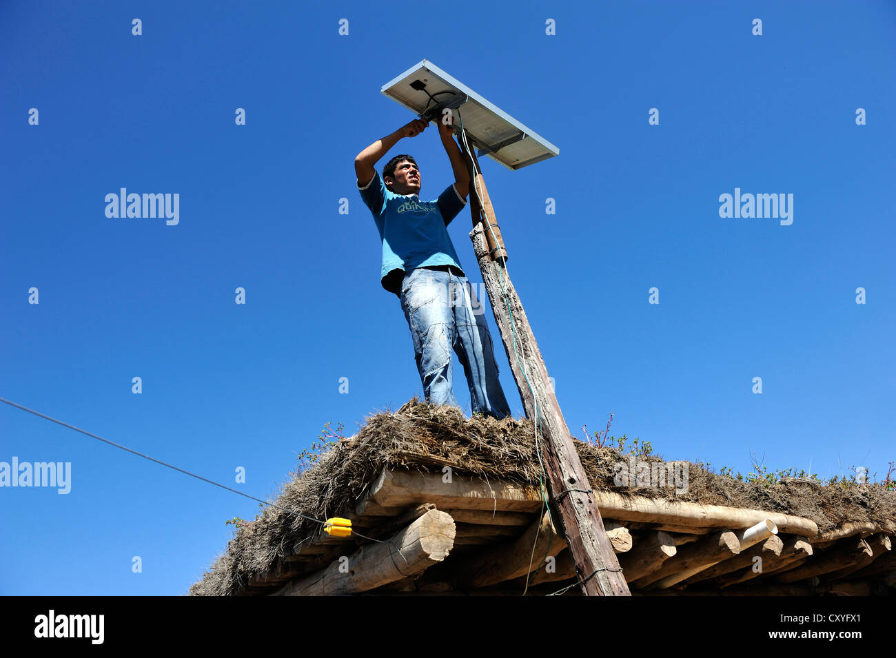 Junger Mann Berg Solarzellen auf dem Dach eine einfache Hütte ein wirtschaftender Bauernhof, Gran Chaco, Provinz Santiago Del Estero Stockfoto