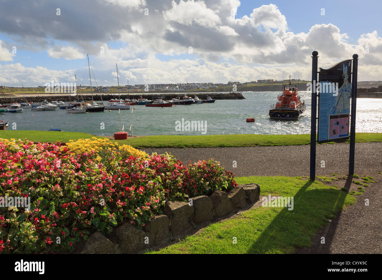 Blick auf Hafen mit Besucherinformation und Rettungsboot vertäut an Nordküste in Portrush, Co. Antrim, Nordirland, Vereinigtes Königreich Stockfoto