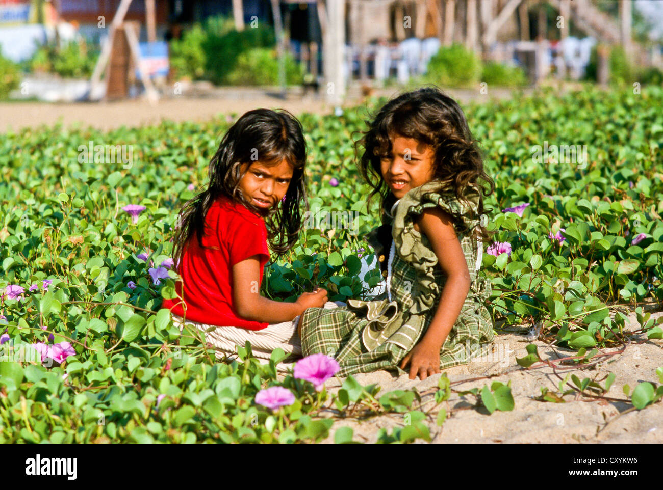 Zwei Mädchen sitzen unter den Blumen, Mahabalipuram, Indien, Asien Stockfoto